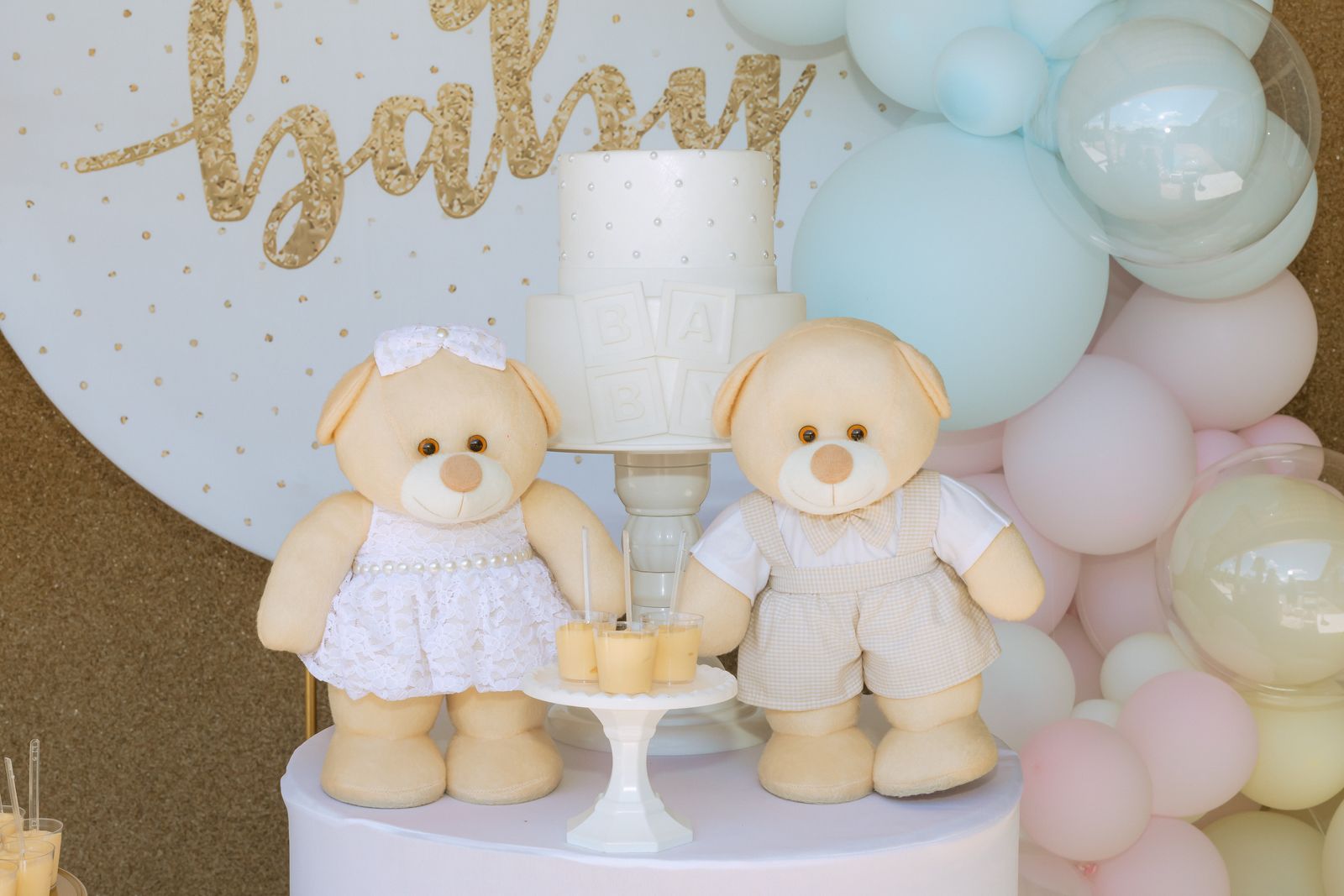 Baby shower decor with teddy bears, cake and pastel balloons